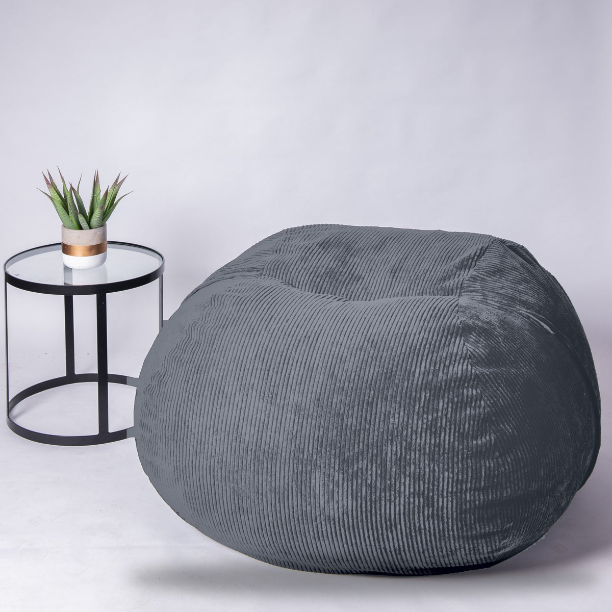 Graphite grey corduroy Shloomfy beanbag in a studio