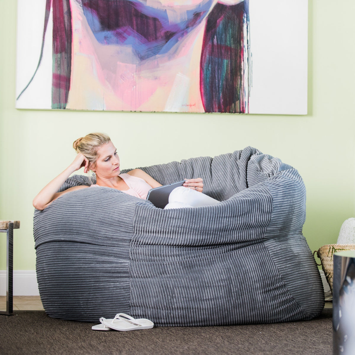 Woman reclining in a Graphite corduroy Shloomfy beanbag
