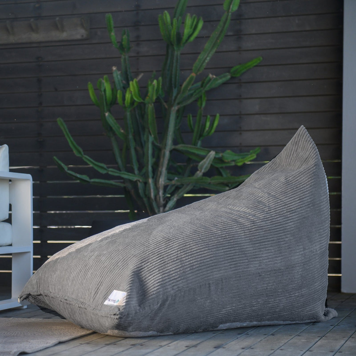 Graphite corduroy Shloomfy lounger on an outdoor deck