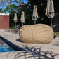 Sand Shloomfy patio beanbag beside a swimming pool